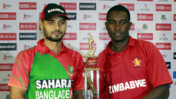 Mashrafe Mortaza and Elton Chigumbura pose with the ODI series trophy at Chittagong on Thursday. Photo: BCB