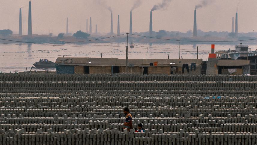 Rows of concrete with brick factories seen in the distance. 