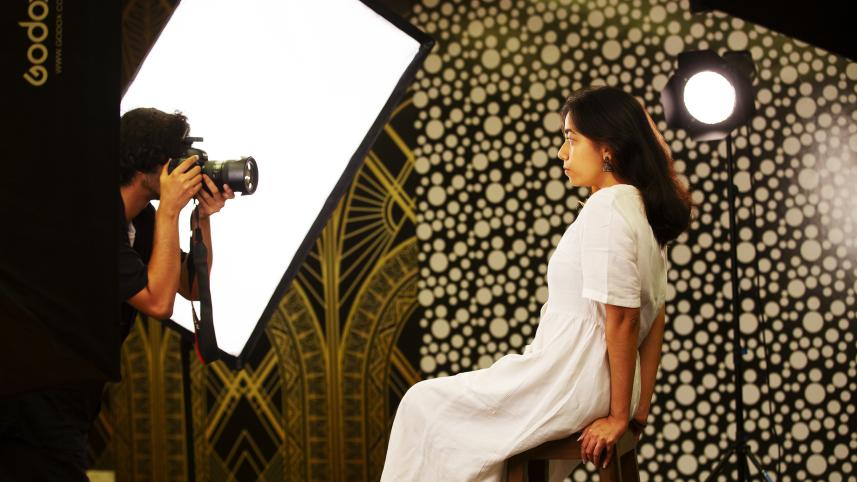 Model posing while photographer prepares to take a picture. 