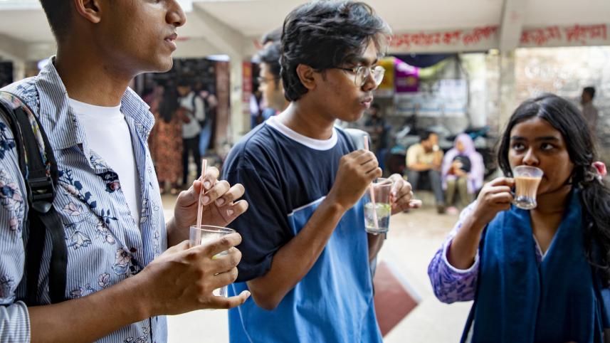 Three students having a cup of cold drink. 