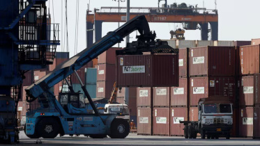 A mobile crane carries a container at Deendayal Port in Kandla