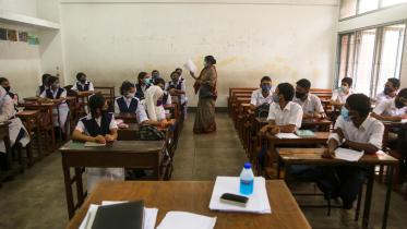 Image shows a teacher in class with students.