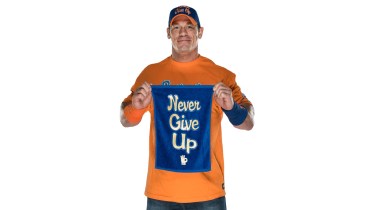 A photo of John Cena holding up a sign saying "Never Give Up"