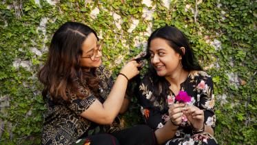 A friend braiding another friends hair.