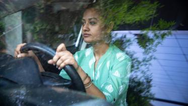 a woman behind the steering wheel of a car