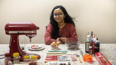 A young entrepreneur and baker with her baking utensils laid out in front of her.