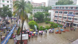 Outside Comilla Government Women's College in Chartha yesterday, several female candidates crossed flooded roads in plastic boats before sitting for their examinations in wet clothes. Photo: Courtesy